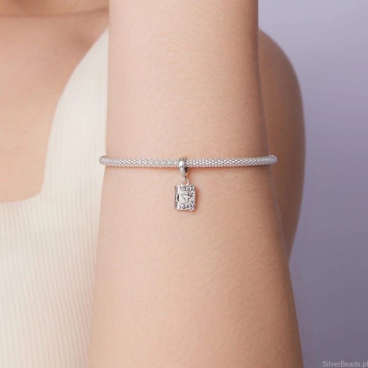 Srebrny charms z krzyżykiem – symbol duchowego wsparcia.