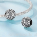 Delikatny charms z ornamentalnymi detalami.