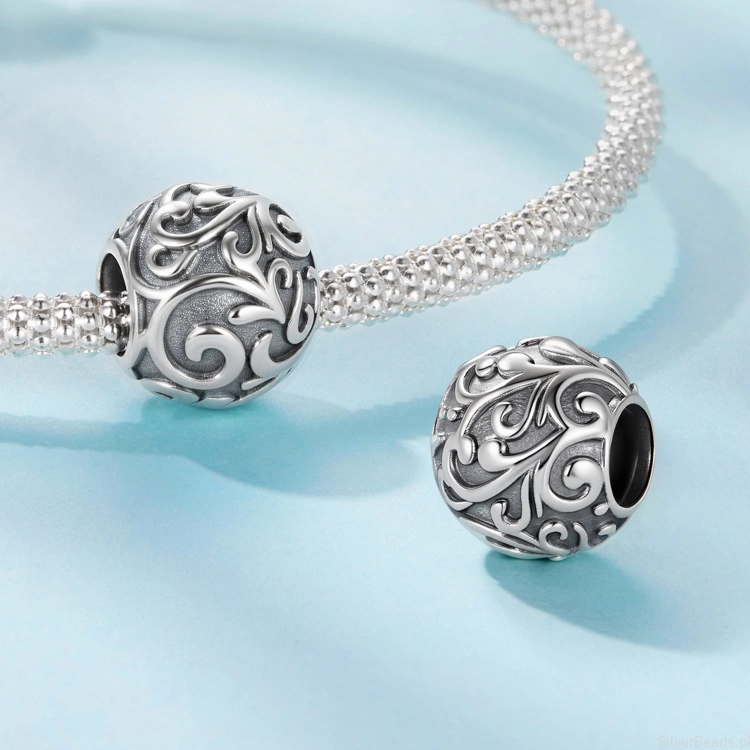 Delikatny charms z ornamentalnymi detalami.