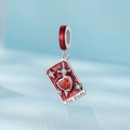 Srebrna zawieszka z mieczem i czerwonym kamieniem w kształcie serca.