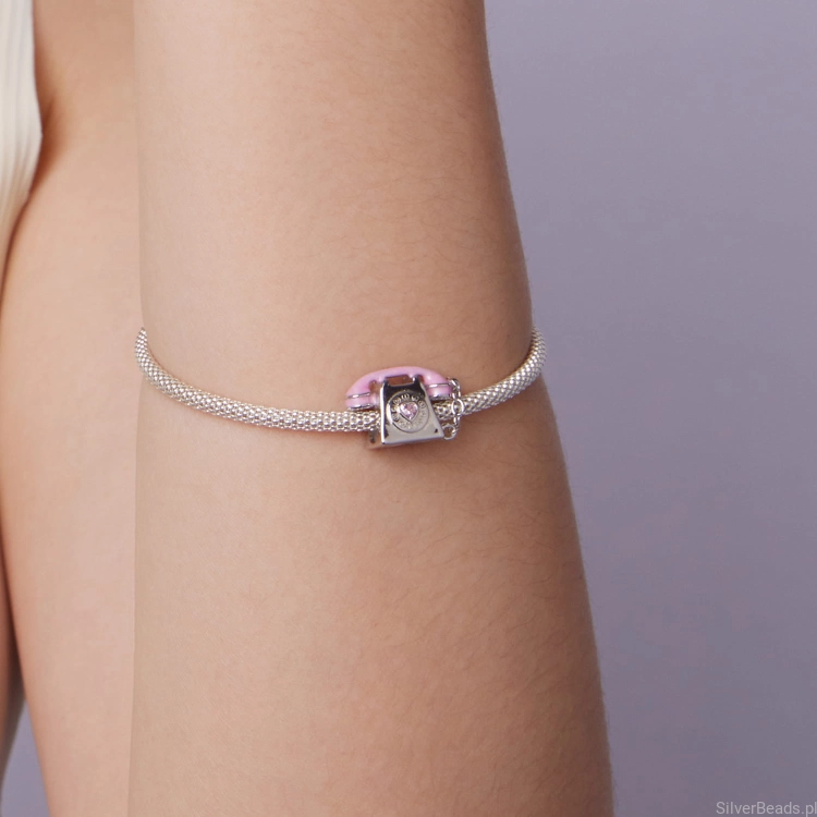 Pastelowy charms z motywem telefonu i błyszczącym kamieniem.