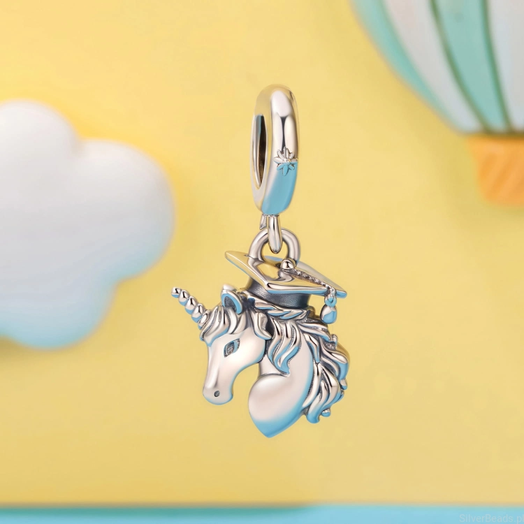 Magiczny charms z jednorożcem w stroju absolwenta.