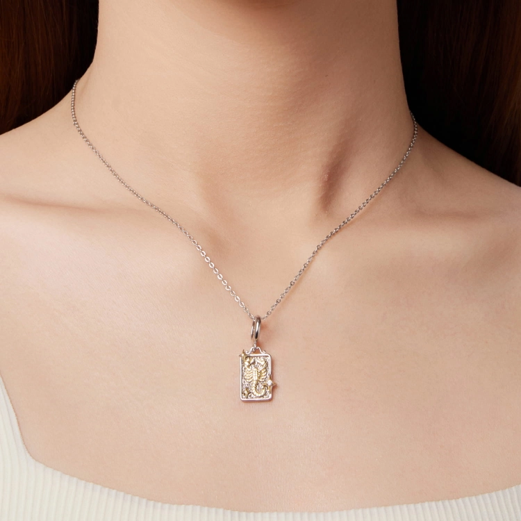 Zodiakalny charms skorpion ozdobiony złotymi gwiazdami.