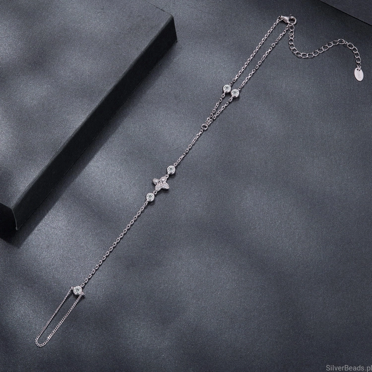 Minimalistyczna hand bracelet z połyskującymi kamieniami.